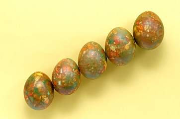marble modern trendy festive easter eggs are located in the center of the frame in increasing order on a yellow bright background with place for text