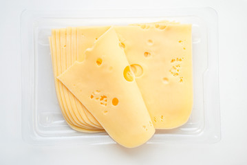 top view close-up of square cheese radamer slices in a package isolated on a white background. Slices of swiss cheese.Maasdam - Dutch hard cheese with large holes.