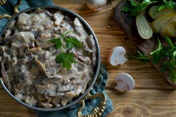 beef Stroganoff in a frying pan on a wooden background