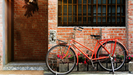 Bicycle leaning on a wall near a window