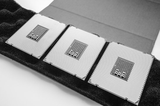 Paris: Above view of three new powerful new professional CPU processor unboxing unpacking new device for the server - black and white