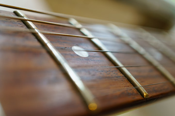 Fragment of a guitar fretboard with strings. Soft focus, shallow depth of field.