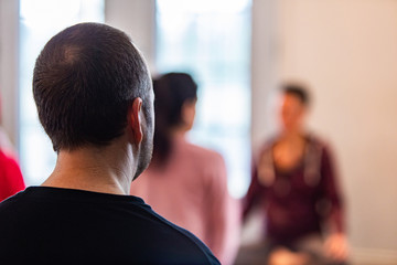 The man engaging in yoga. Rear view of a man who practices yoga in a special class. The guy who learns yoga in a special center