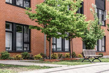 Green trees in front of a modern brick building