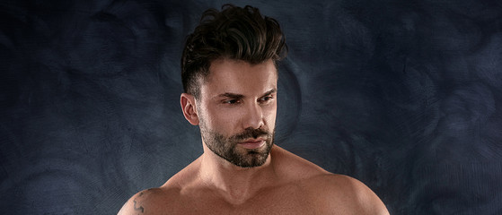 Muscular model, brunet man on dark background