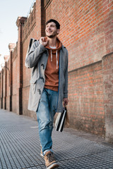 Fototapeta na wymiar Young man holding shopping bags while walking on the street.