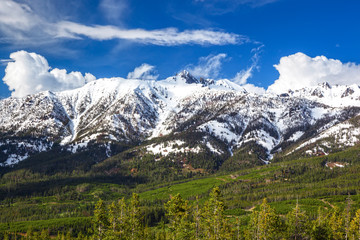 Fototapeta premium Snow capped mountains of Lone Mountain with blue sky and wispy clouds, in the Madison Ranges, Big Sky, Montana, United States of America
