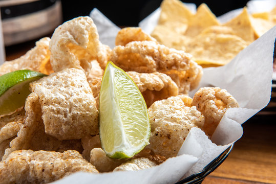 Pork Rinds also called chicharron or chicharrones and tortilla chips with salsa