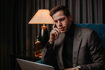 Junger Unternehmer arbeitet in einer Hotel Lobby am Laptop 
