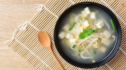Mung bean sprouts soup with sliced tofu in a bowl, Asian vegan food, Top view
