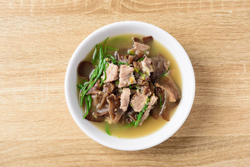 Spicy brown jelly mushroom soup with pork in a bowl on wooden table, Local Thai food, Top view