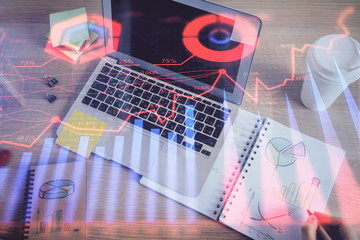 Double exposure of man's hands writing notes of stock market with forex chart.