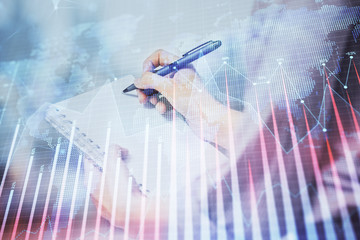 Multi exposure of hands making notes with forex chart huds. Stock market concept.