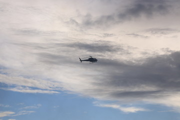 A silhoutte of a helicopter against the evening sky