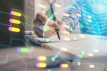 Double exposure of hands making notes with world map hologram and data theme icons. Concept of international network data.