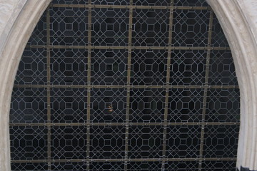 Large glass in lead windown of a church showing a close up of the squared design inside the class