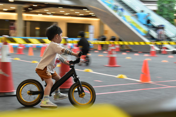 kid playing balance bike in racetrack, speed motion blur image