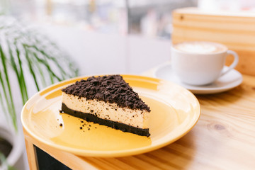 One slice of cake on a yellow plate in a coffee shop