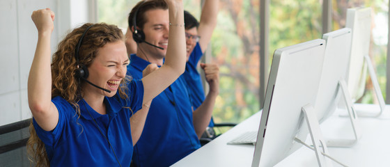 customer service and call center agents show exited and happy with fists up for being success in...