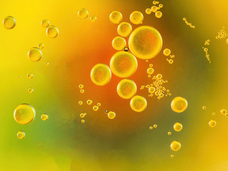 oil bubble on water with yellow orange and green background