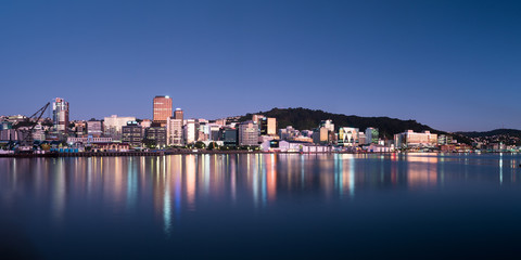 Wellington, New Zealand city buildings and skyline reflected in the harbour at sunrise on a perfect summer morning. 