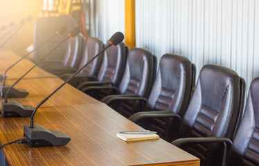microphone ,pen and paper on table before business meeting,empty corporate conference room