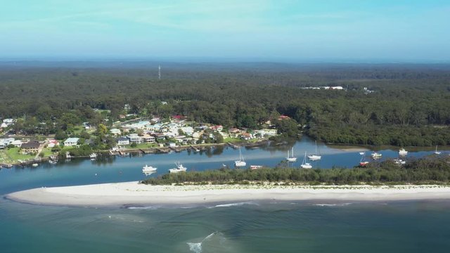 Aerial drone view of boats and yachts moored on Currambene Creek at Huskisson, Jervis Bay on the New South Wales South Coast, Australia, on a bright sunny day   