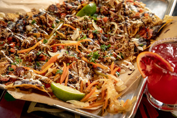 Platter of pulled pork nachos with margarita