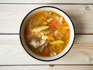 Soup in a white plate. Red soup of Russian cabbage, tomato paste. View from above