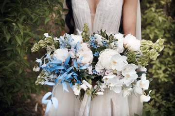 gorgeous bouquet of colored flowers in the hands of the bride
