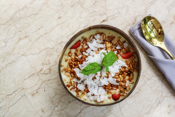 Smoothie bowl with mango, yogurt, granola and strawberry
