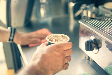 closeup of hand holding iced coffee 