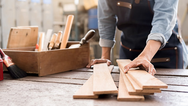 Carpenter working with equipment on wooden table in carpentry shop. woman works in a carpentry shop.