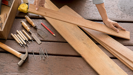 Carpenter working with equipment on wooden table in carpentry shop. woman works in a carpentry shop.