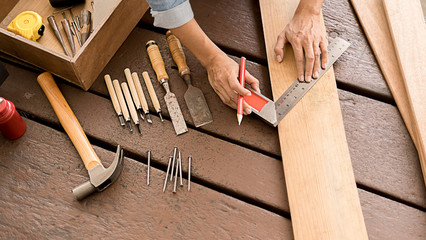 Carpenter working with equipment on wooden table in carpentry shop. woman works in a carpentry shop.