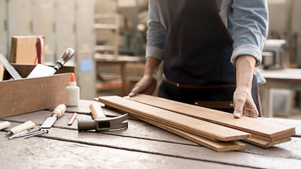 Carpenter working with equipment on wooden table in carpentry shop. woman works in a carpentry shop.