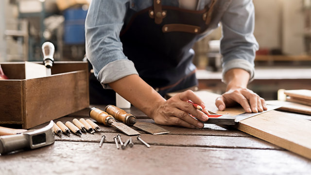 Carpenter working with equipment on wooden table in carpentry shop. woman works in a carpentry shop.