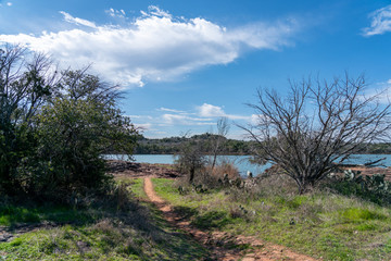 View of Walking Trail Through TExas Inks Lake Park With Lake in the background