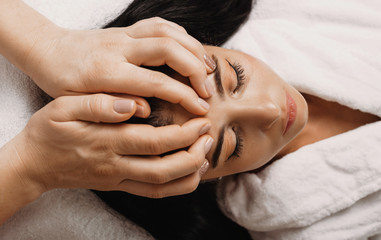 Fototapeta na wymiar Charming brunette caucasian girl who is resting with closed eyes while taking pleasure from spa procedures