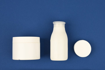 White empty cosmetic tubes on a blue background of 2020. Skin care concept. With copy space. The apartment was lying. View from above. Dermatology, closeup.