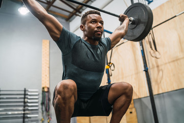 Crossfit athlete doing exercise with a barbell.