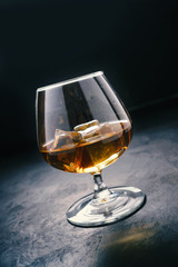 Cognac in a glass with ice. Strong alcohol.