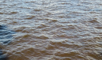 Soft waves on the gray blue water surface, natural background 