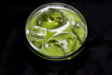 Fresh green healthy cucumber smoothie isolated on black background