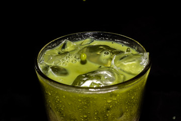 Fresh green healthy cucumber smoothie isolated on black background