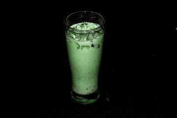 Fresh green healthy cucumber smoothie isolated on black background