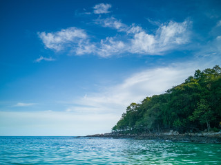 Beachfront next to a beautiful hill under a tree in a beautiful cloud day.