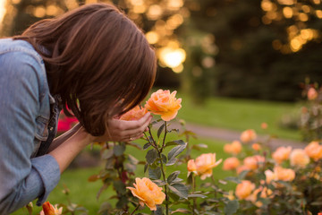 Obraz na płótnie Canvas Girl smelling orange roses