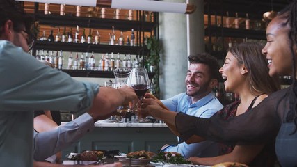 Group of friends meeting in restaurant celebrating and making a toast - shot in slow motion - Powered by Adobe