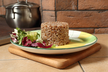 Cooked buckwheat porridge with salad on plate